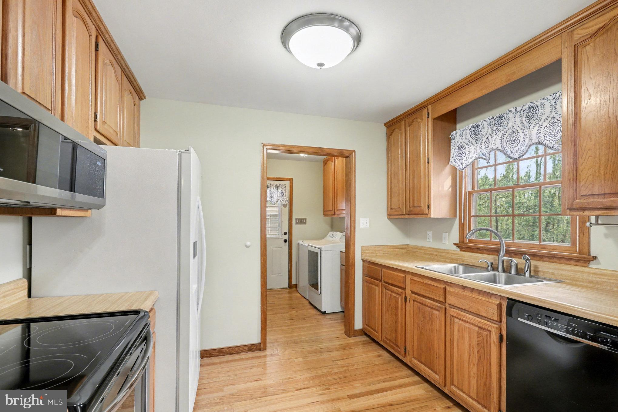 259 Hawkins Farm Road Bumpass, VA 23024 - Photo 6 of 24 a kitchen with a sink and a refrigerator