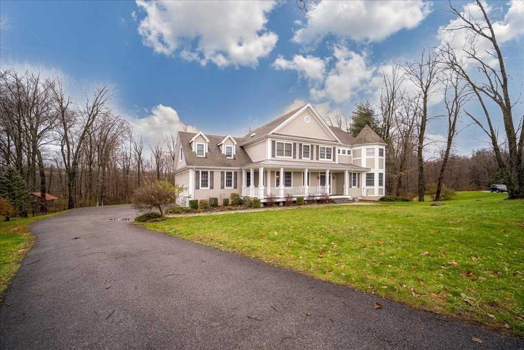 a view of a house with a big yard and large trees