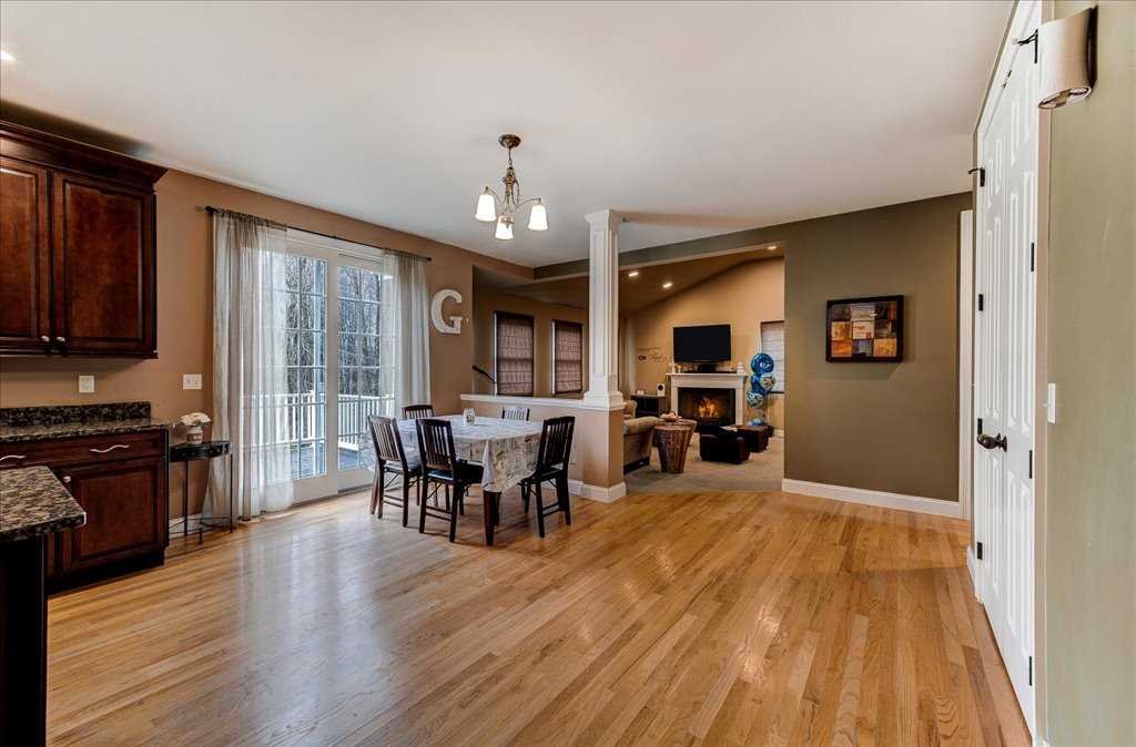 107 Roundhill Road East Fishkill, NY 12533 - Photo 12 of 38 a open kitchen with stainless steel appliances granite countertop a stove top oven a dining table and chairs with wooden floor