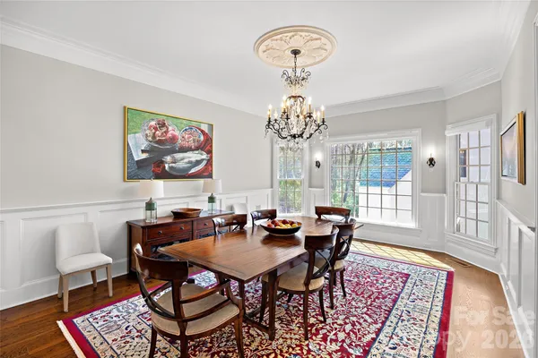a view of a dining room with furniture a chandelier and wooden floor
