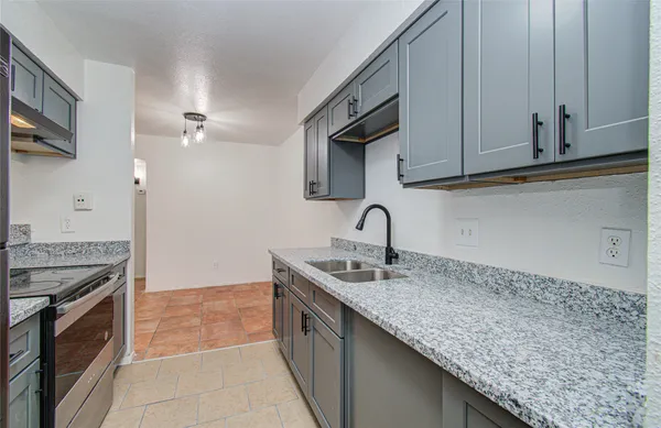 a kitchen with granite countertop a sink stainless steel appliances and cabinets