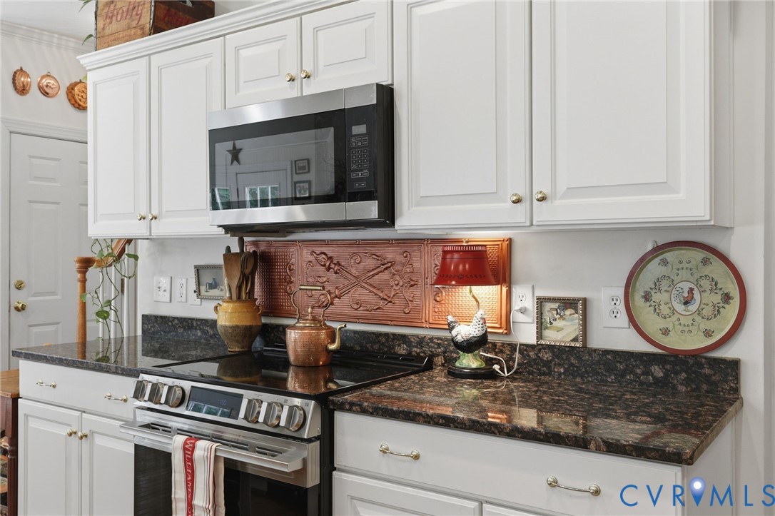 13424 Tipple Point Road Midlothian, VA 23114 - Photo 14 of 53 a kitchen with stainless steel appliances granite countertop a stove a microwave and cabinets