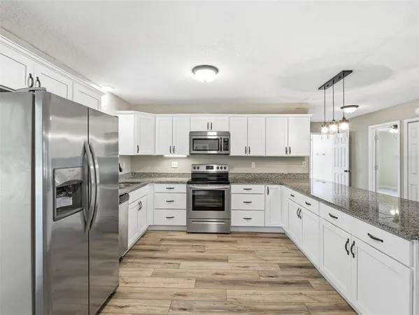a kitchen with white cabinets stainless steel appliances and sink