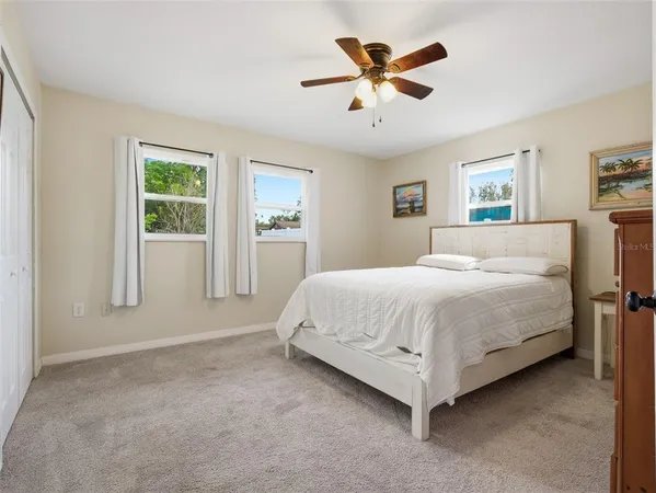a bedroom with a bed dresser and a chandelier