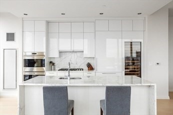 1 Franklin Street, Unit 5105 Boston, MA 02110 - Photo 2 of 24 a kitchen with stainless steel appliances granite countertop a sink a stove and refrigerator