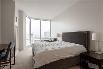 1 Franklin Street, Unit 5105 Boston, MA 02110 - Photo 6 of 24 a bedroom with a bed and a large window