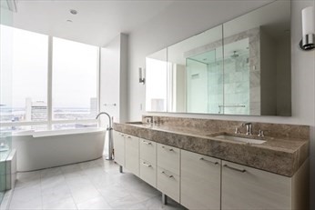 1 Franklin Street, Unit 5105 Boston, MA 02110 - Photo 7 of 24 a bathroom with a granite countertop sink and a large mirror
