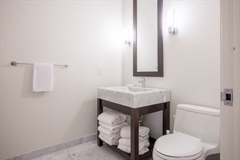 1 Franklin Street, Unit 5105 Boston, MA 02110 - Photo 9 of 24 a bathroom with a sink toilet and mirror