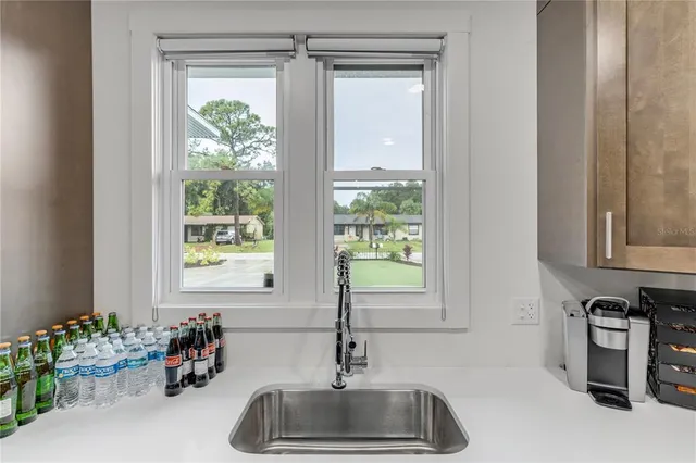 a view of a kitchen with kitchen island stainless steel appliances a sink and wooden floor