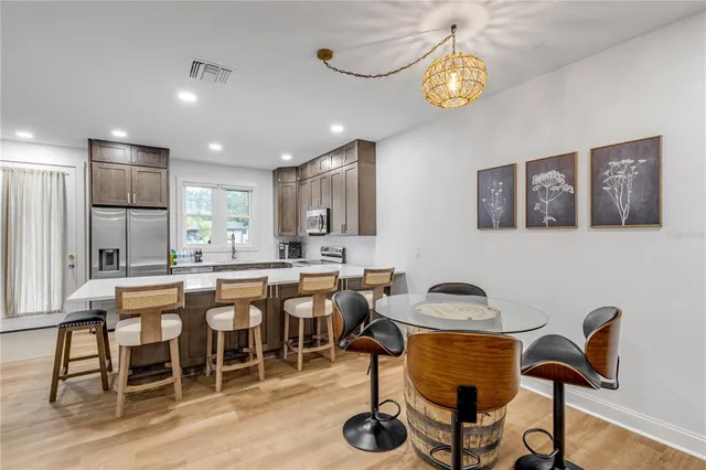 a living room with furniture and a flat screen tv with kitchen view