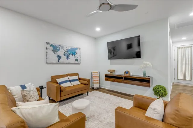 a living room with furniture and a ceiling fan