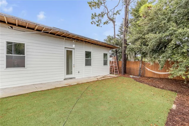 a view of a house with backyard and sitting area
