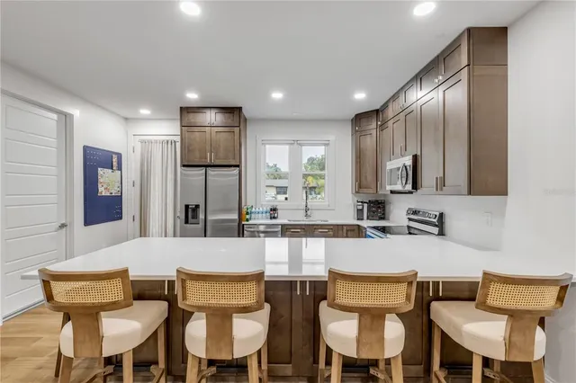 a kitchen with a dining table chairs and refrigerator