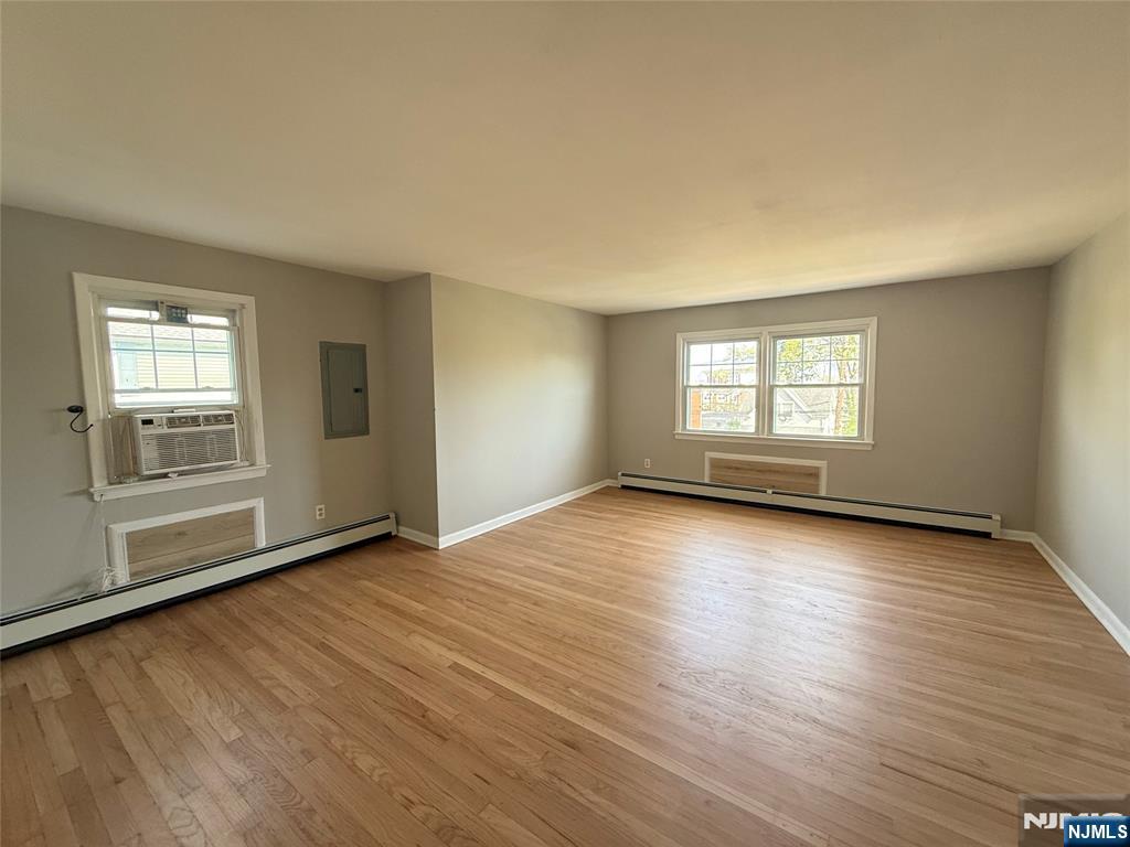 175 Van Winkle Street, Unit 2 East Rutherford, NJ 07073 - Photo 5 of 20 an empty room with wooden floor and windows