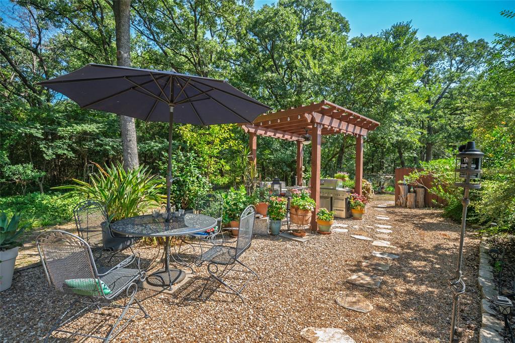 1516 Rancho Road Quinlan, TX 75474 - Photo 31 of 40 a view of wooden chairs and table under an umbrella