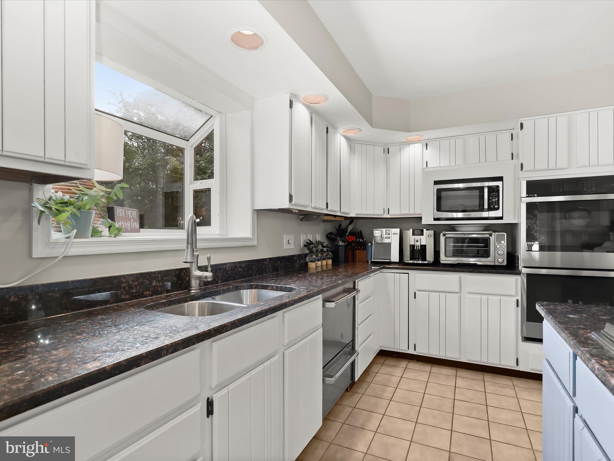 10901 Moxley Road Damascus, MD 20872 - Photo 20 of 148 a kitchen with granite countertop a sink a window and stainless steel appliances