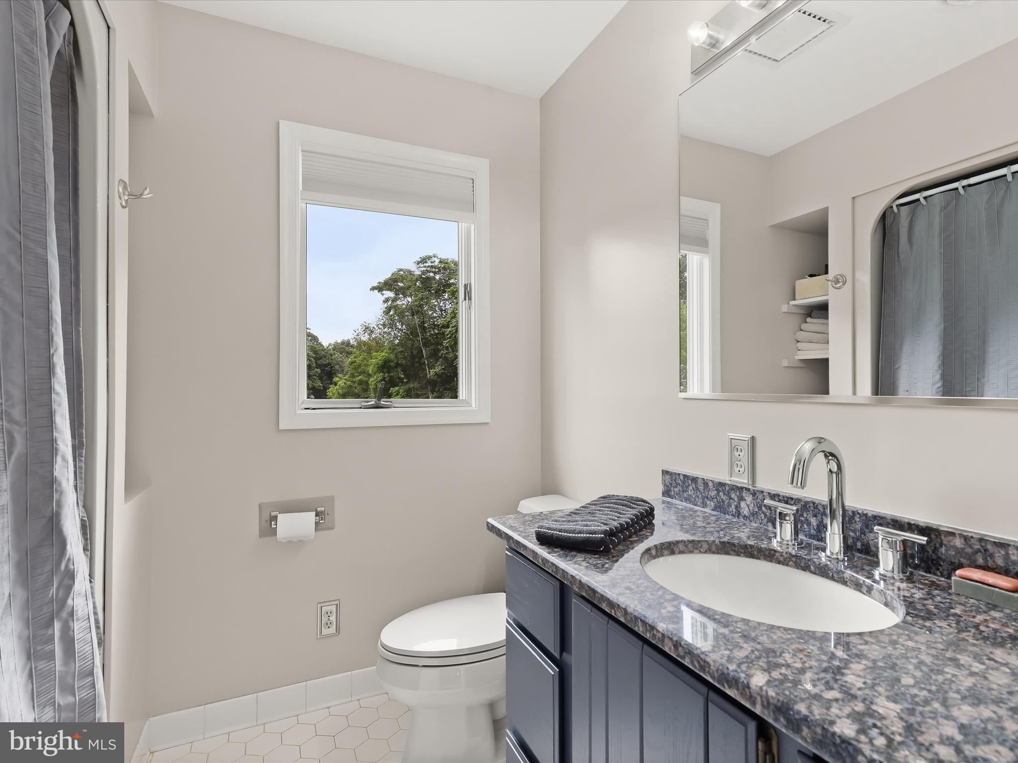 10901 Moxley Road Damascus, MD 20872 - Photo 45 of 148 a bathroom with a granite countertop toilet a sink and a mirror