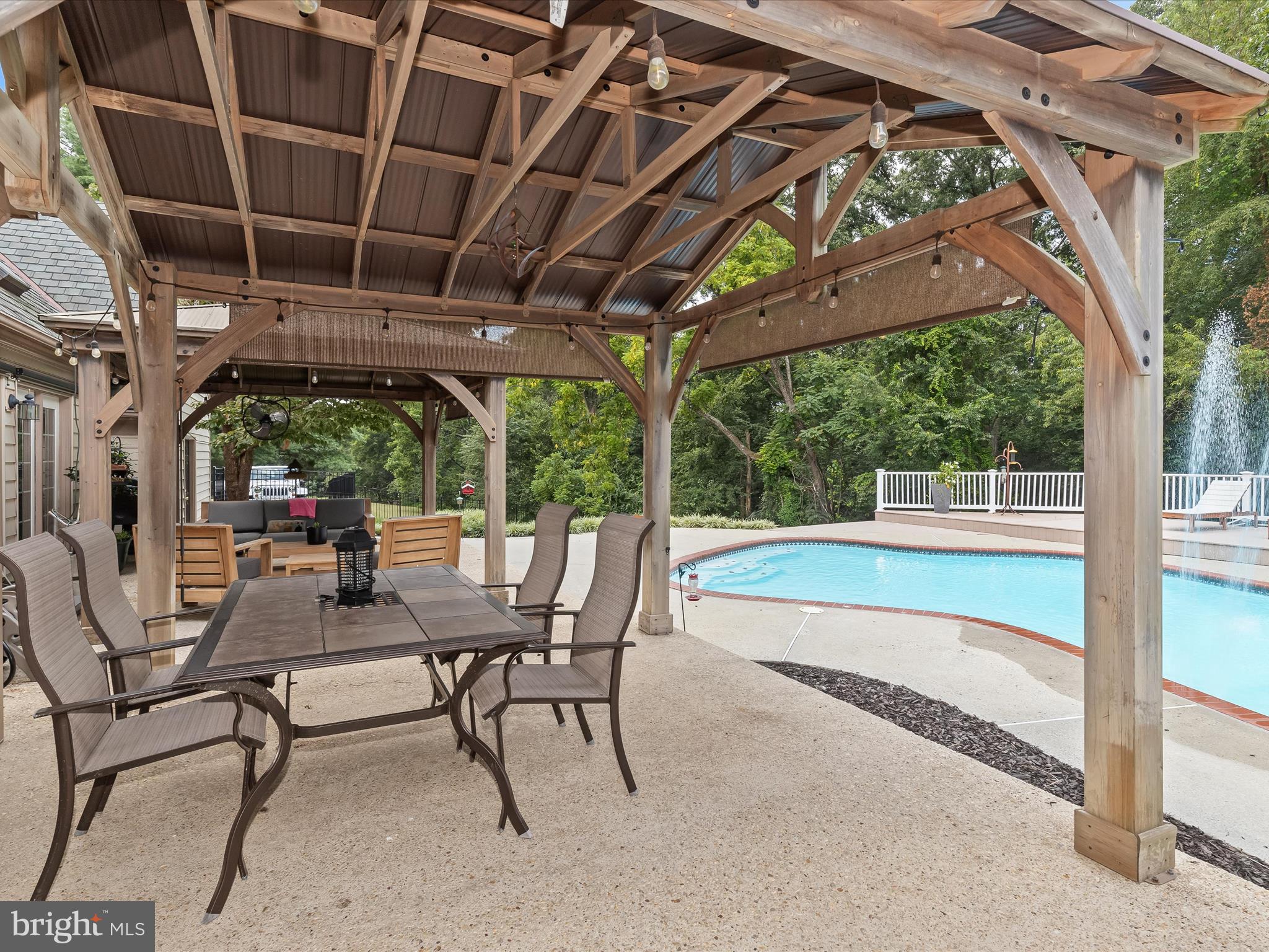 10901 Moxley Road Damascus, MD 20872 - Photo 55 of 148 a view of a patio with table and chairs next to a yard with wooden floor