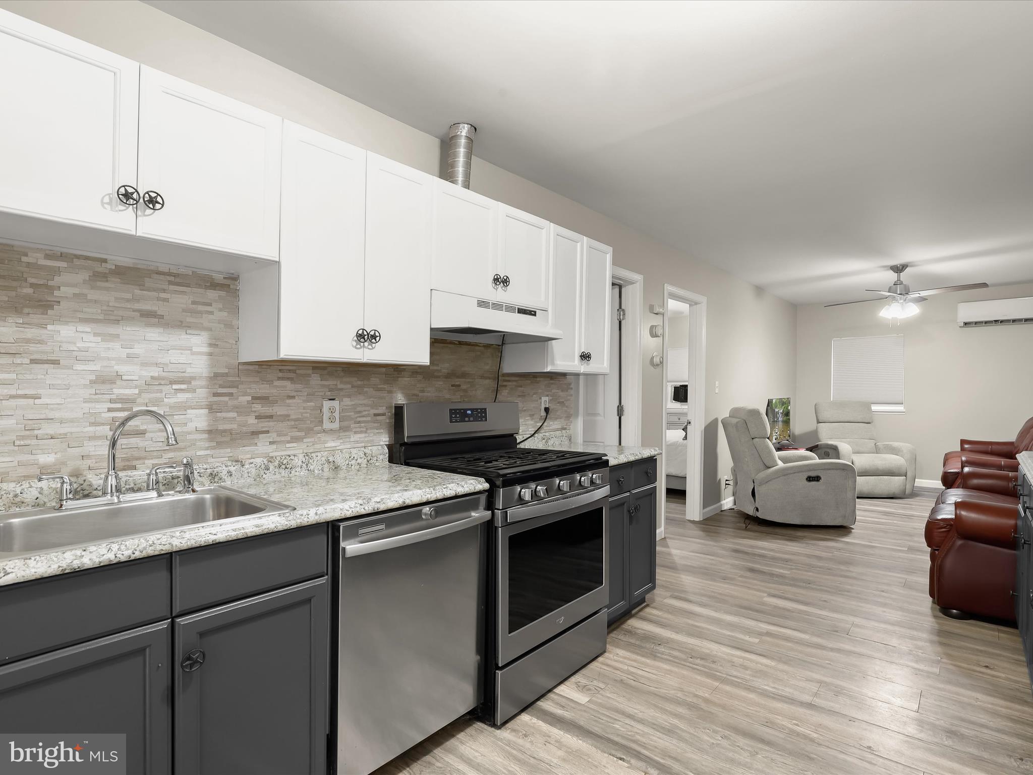10901 Moxley Road Damascus, MD 20872 - Photo 93 of 148 a kitchen with stainless steel appliances white cabinets a sink dishwasher a stove and a refrigerator with wooden floor