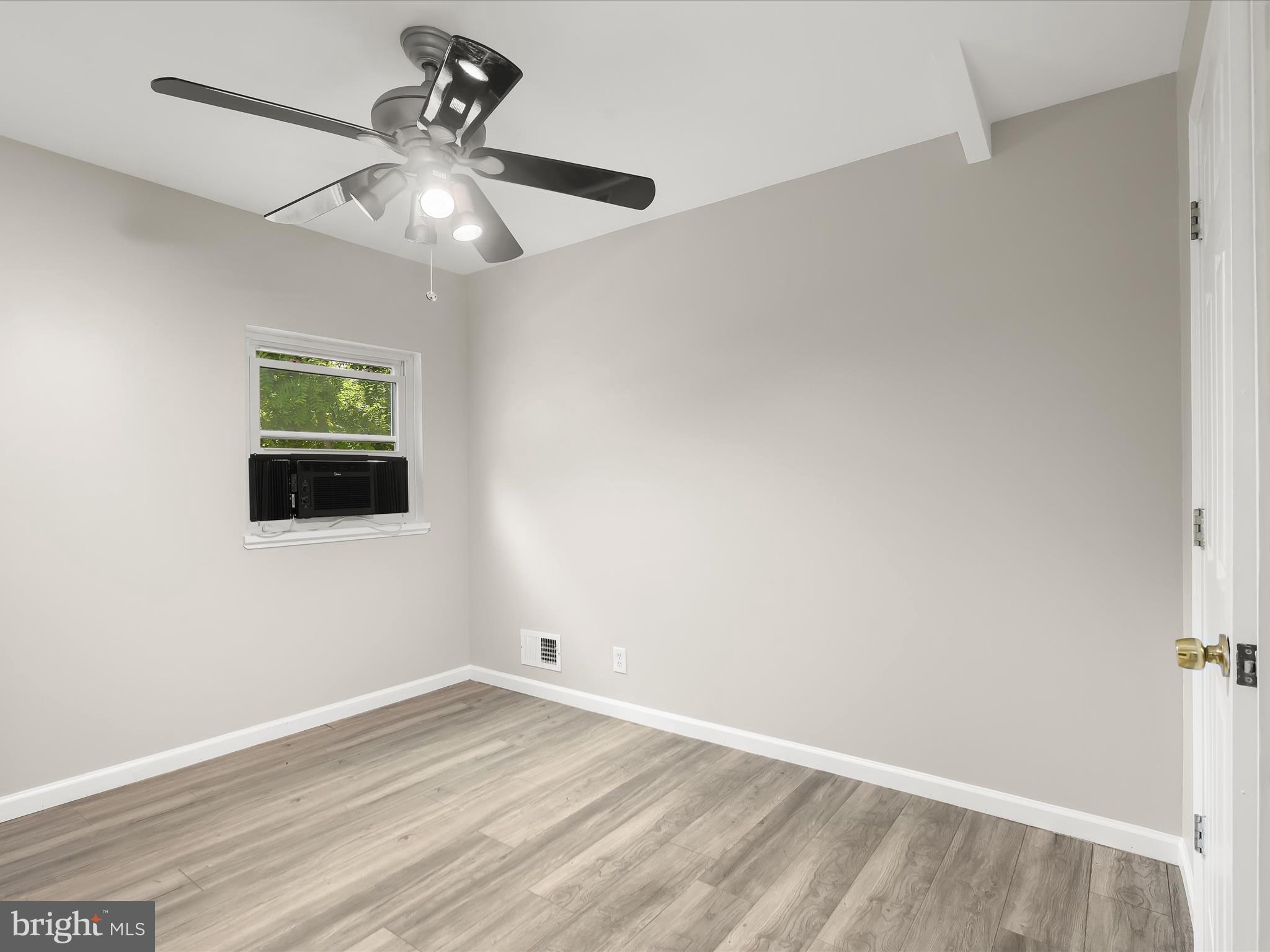 10901 Moxley Road Damascus, MD 20872 - Photo 98 of 148 an empty room with wooden floor chandelier fan and windows