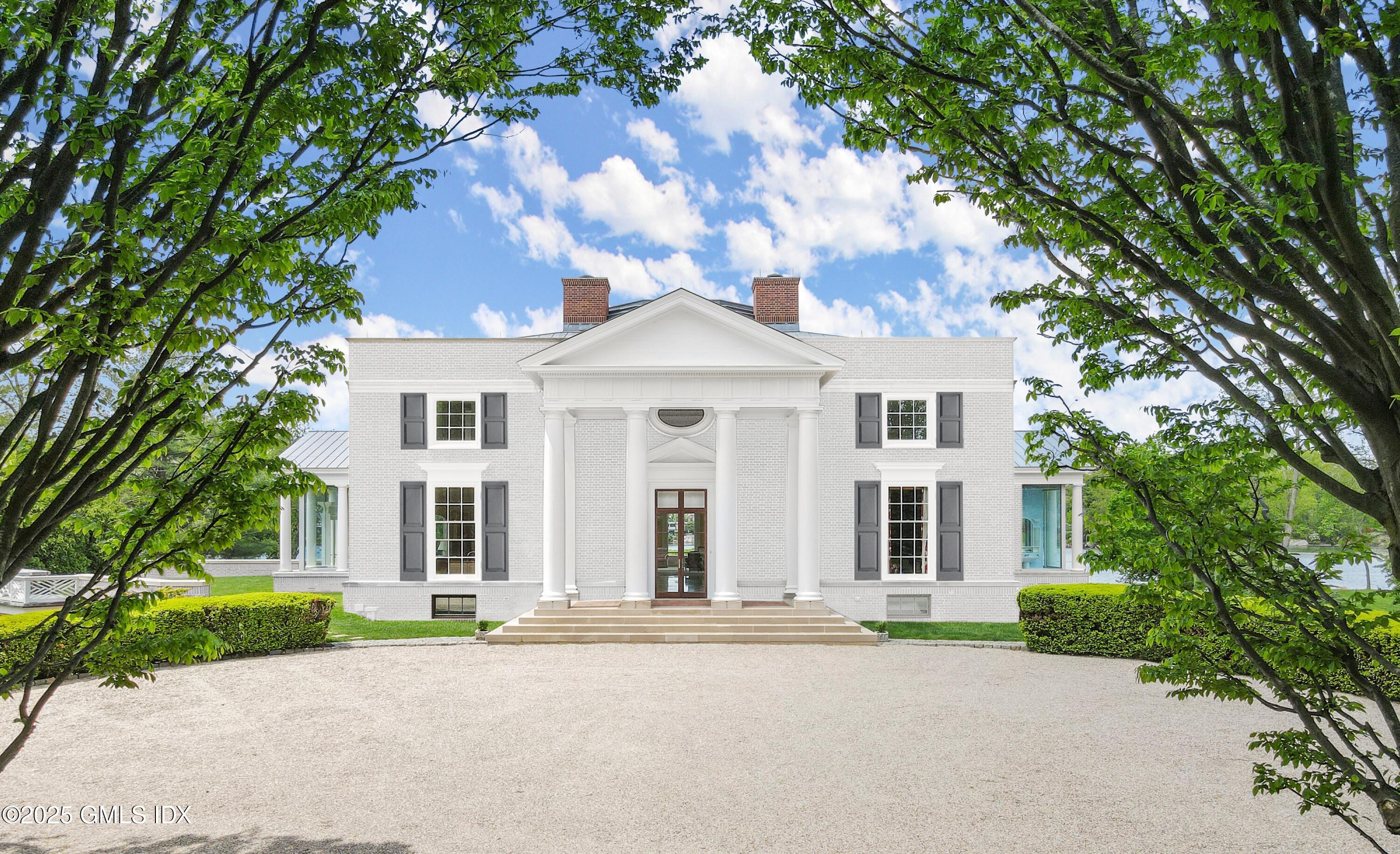 16 Windrose Way Greenwich, CT 06830 - Photo 3 of 18 front view of a house with a garden