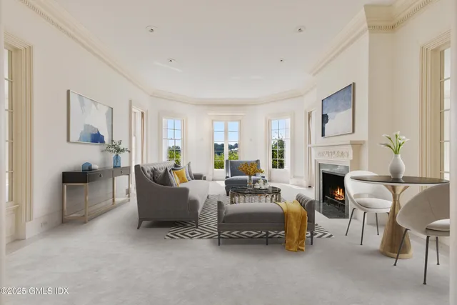 a living room with furniture a fireplace and a large window