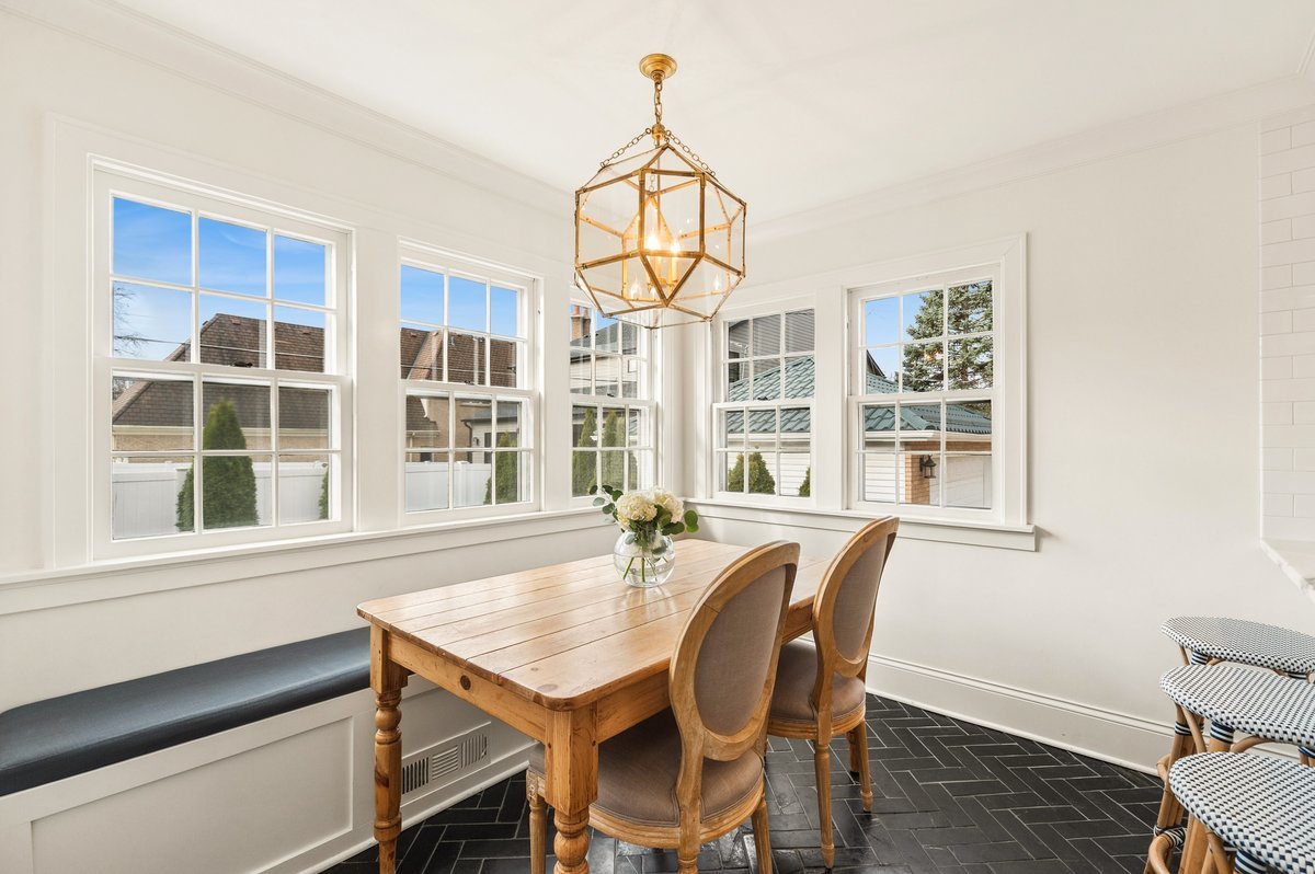240 West St Charles Road Elmhurst, IL 60126 - Photo 16 of 41 a dining room with wooden floor a chandelier a wooden table and chairs