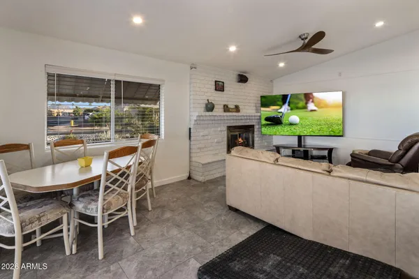 a living room with furniture a floor to ceiling window and flat screen tv