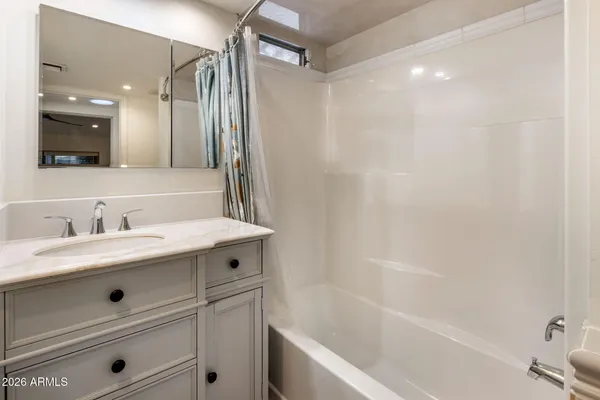 a bathroom with a sink a toilet a mirror and shower