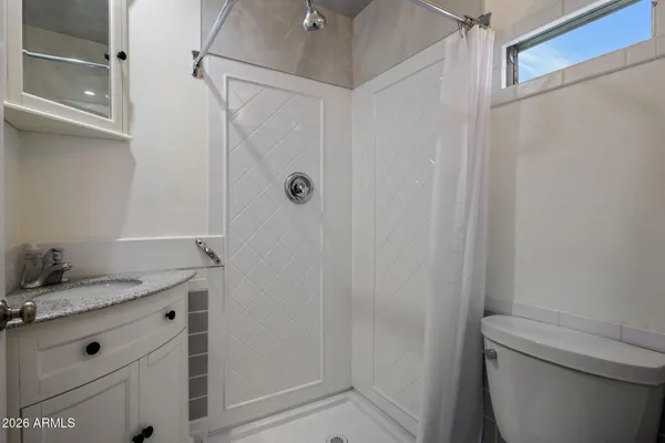 a bathroom with a granite countertop sink toilet and shower