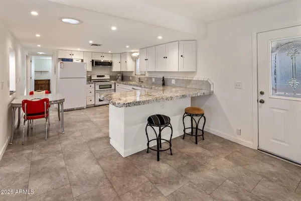a kitchen with kitchen island white cabinets and stainless steel appliances