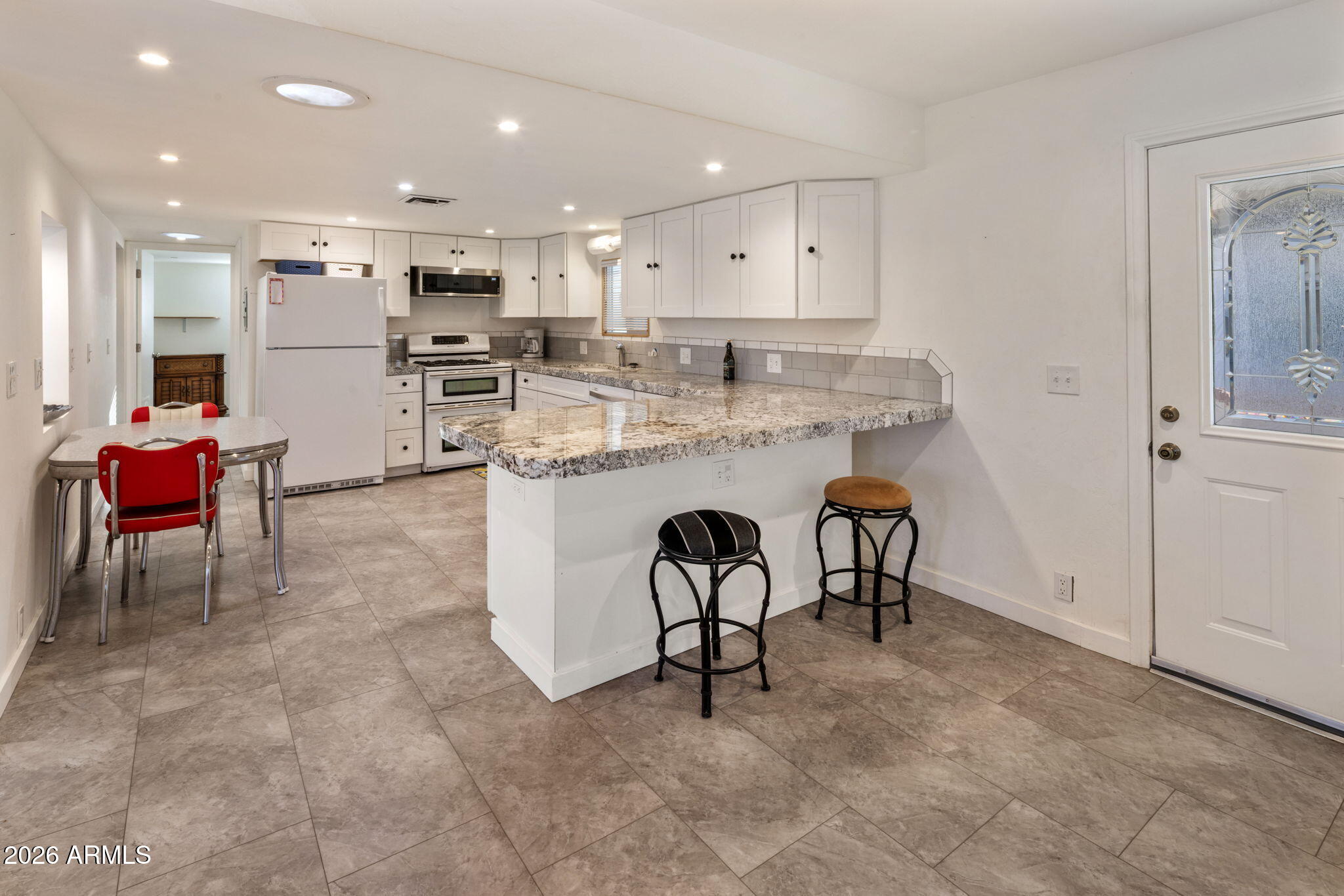 2311 North Gayridge Road Mesa, AZ 85215 - Photo 5 of 31 a kitchen with kitchen island white cabinets and stainless steel appliances
