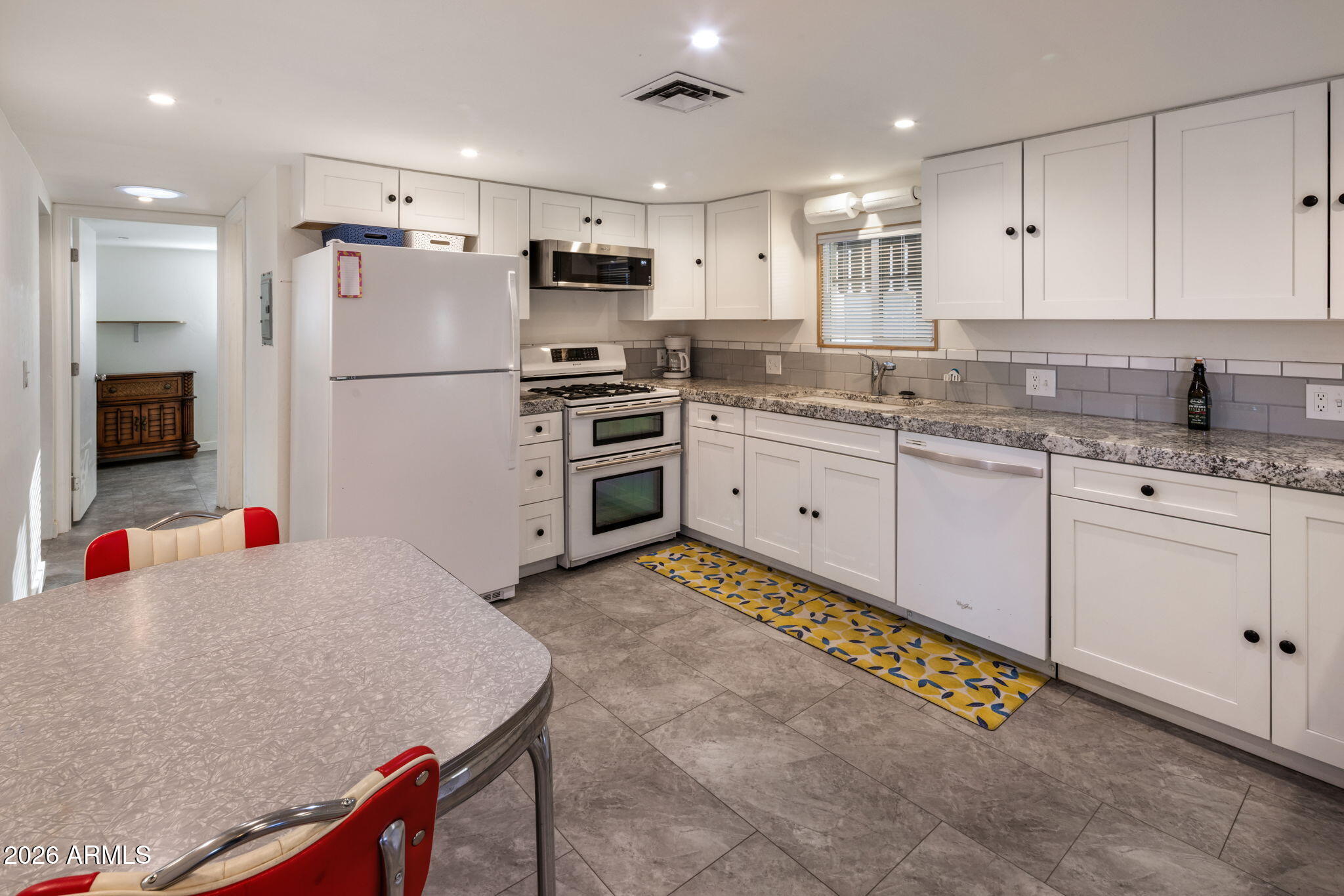 2311 North Gayridge Road Mesa, AZ 85215 - Photo 6 of 31 a kitchen with granite countertop a sink stainless steel appliances and white cabinets