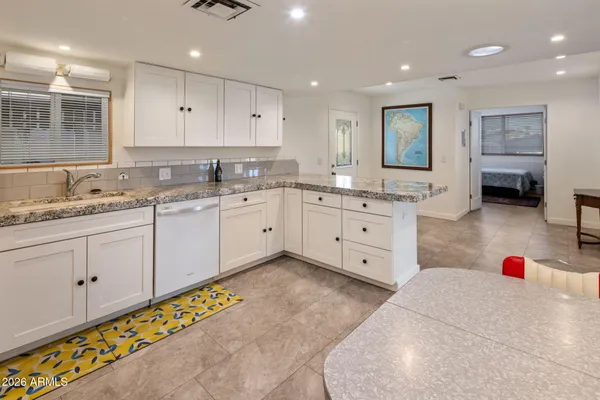 a large white kitchen with cabinets