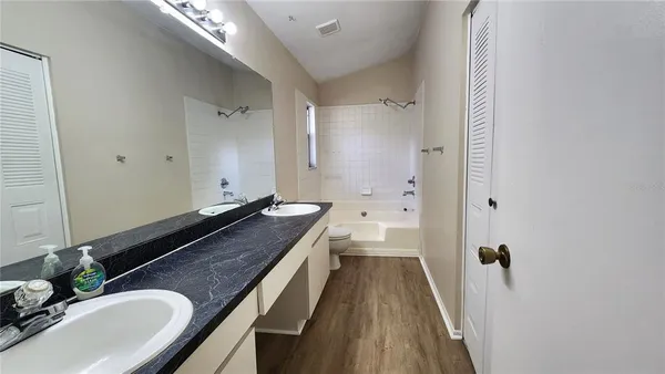 a bathroom with a granite countertop sink a mirror and a shower
