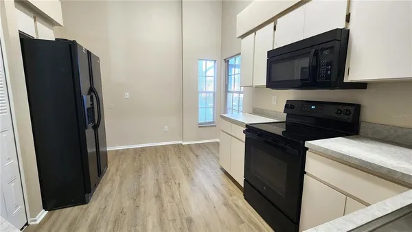 a kitchen with a refrigerator stove and wooden cabinets