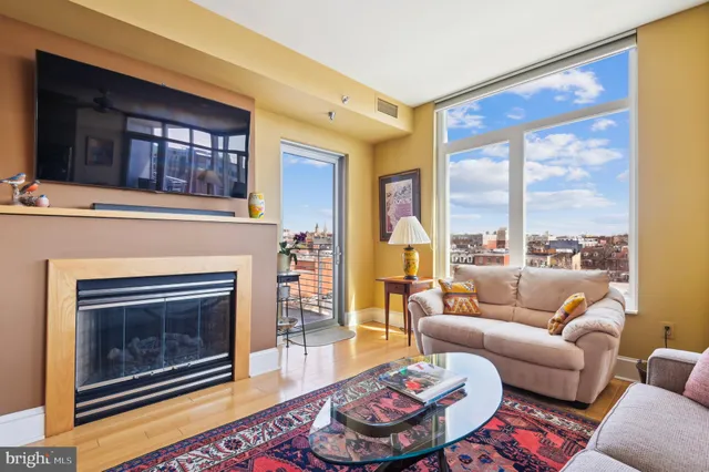 a living room with furniture a fireplace and a floor to ceiling window