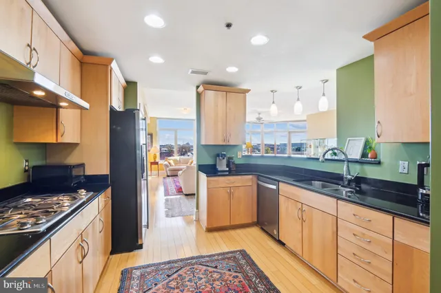 a kitchen with stainless steel appliances granite countertop a stove a sink and a refrigerator