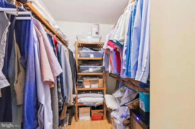 a view of walk in closet with clothes and shoes