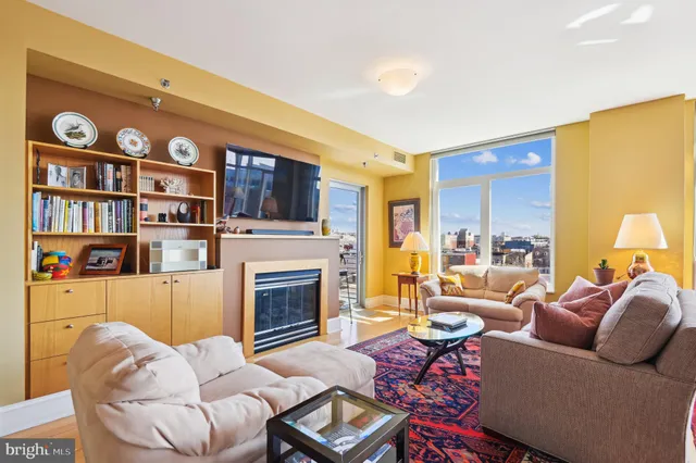 a living room with furniture fireplace and a large window