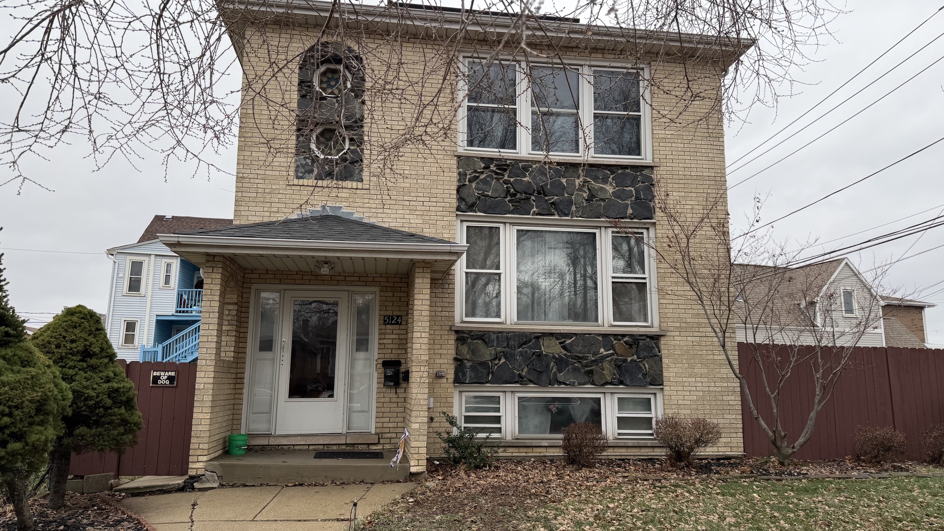 a front view of a house with a tree