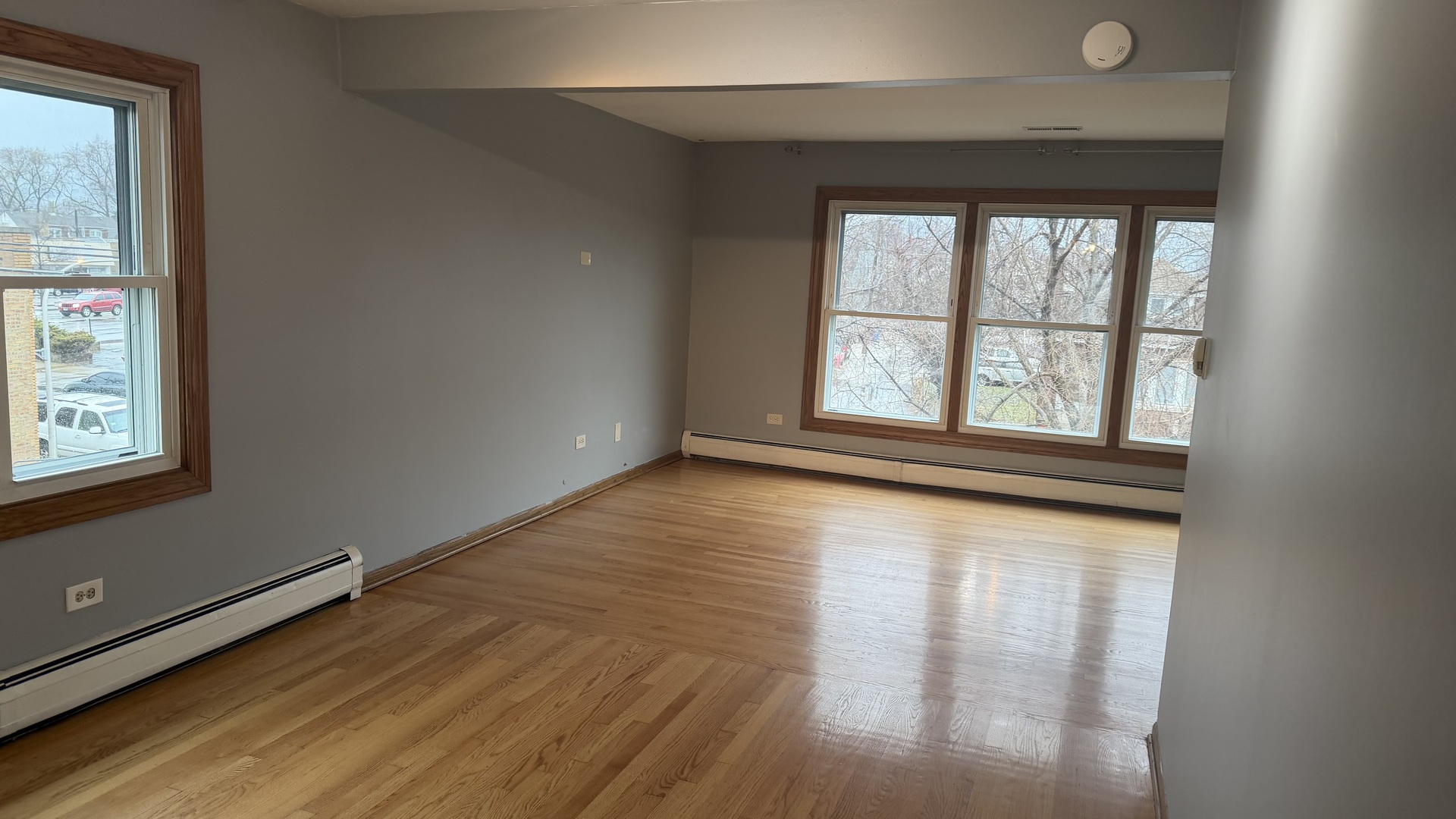 5124 South Kostner Avenue, Unit 2 Chicago, IL 60632 - Photo 2 of 12 an empty room with wooden floor and windows
