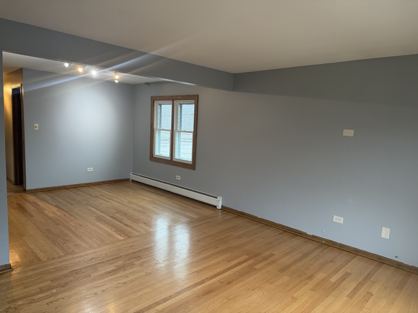 5124 South Kostner Avenue, Unit 2 Chicago, IL 60632 - Photo 5 of 12 an empty room with wooden floor and windows