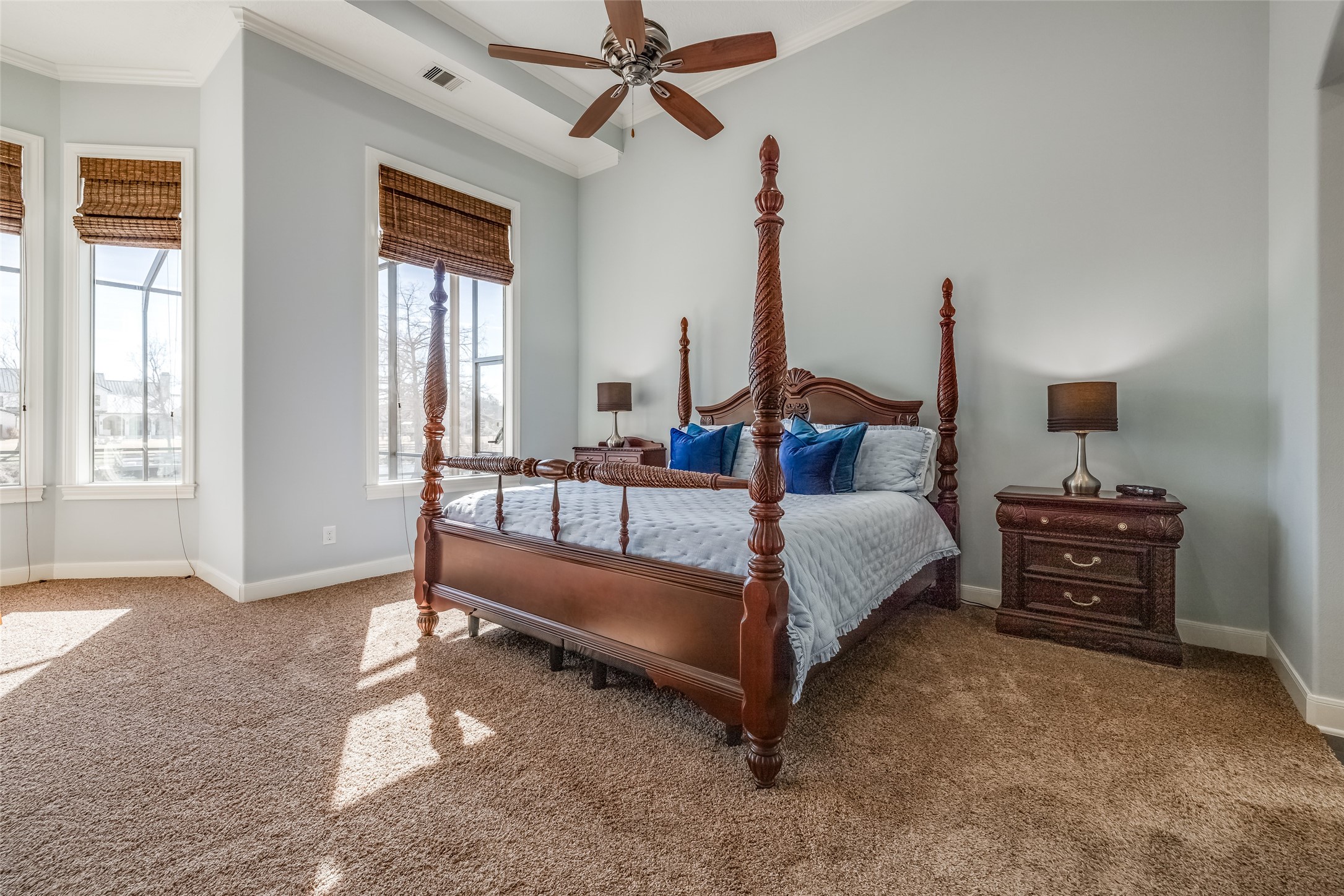 31102 Lower Oxbow Trace Fulshear, TX 77441 - Photo 20 of 50 Fabulous Primary Suite with room for a super king bed & sitting area, wall of window with lots of natural light, door out to the pool & Oxbow Lake. Rattan Blinds, carpet. 2 large Closets