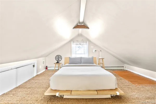 a spacious bedroom with a bed and a chandelier