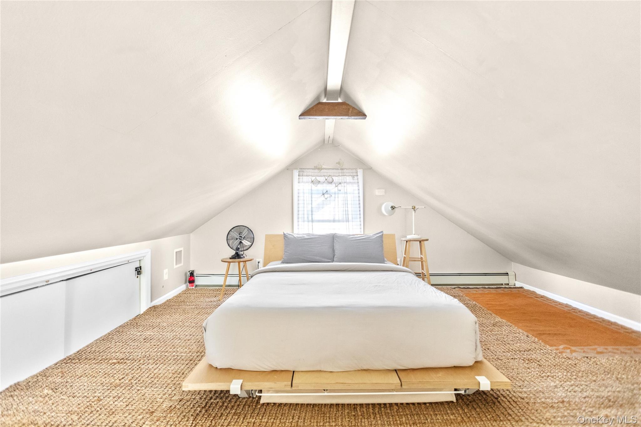 47 Station Road Bellport, NY 11713 - Photo 10 of 13 a spacious bedroom with a bed and a chandelier