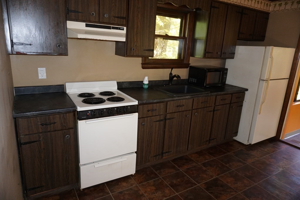 147 Thicket Road Tolland, MA 01034 - Photo 11 of 19 a kitchen with granite countertop a sink cabinets and stainless steel appliances