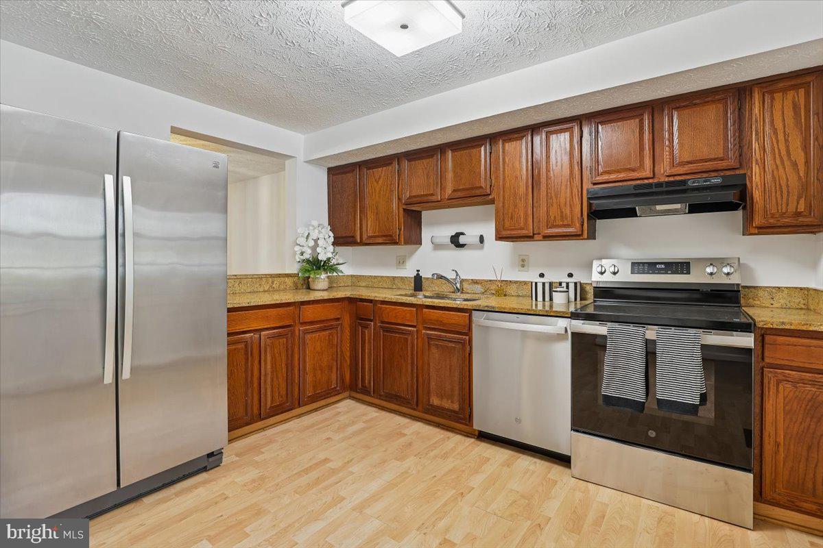 10921 Harpers Square Court Reston, VA 20191 - Photo 5 of 33 a kitchen with stainless steel appliances granite countertop a refrigerator sink and cabinets