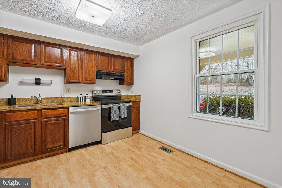 10921 Harpers Square Court Reston, VA 20191 - Photo 7 of 33 a kitchen with stainless steel appliances granite countertop a stove sink and cabinets