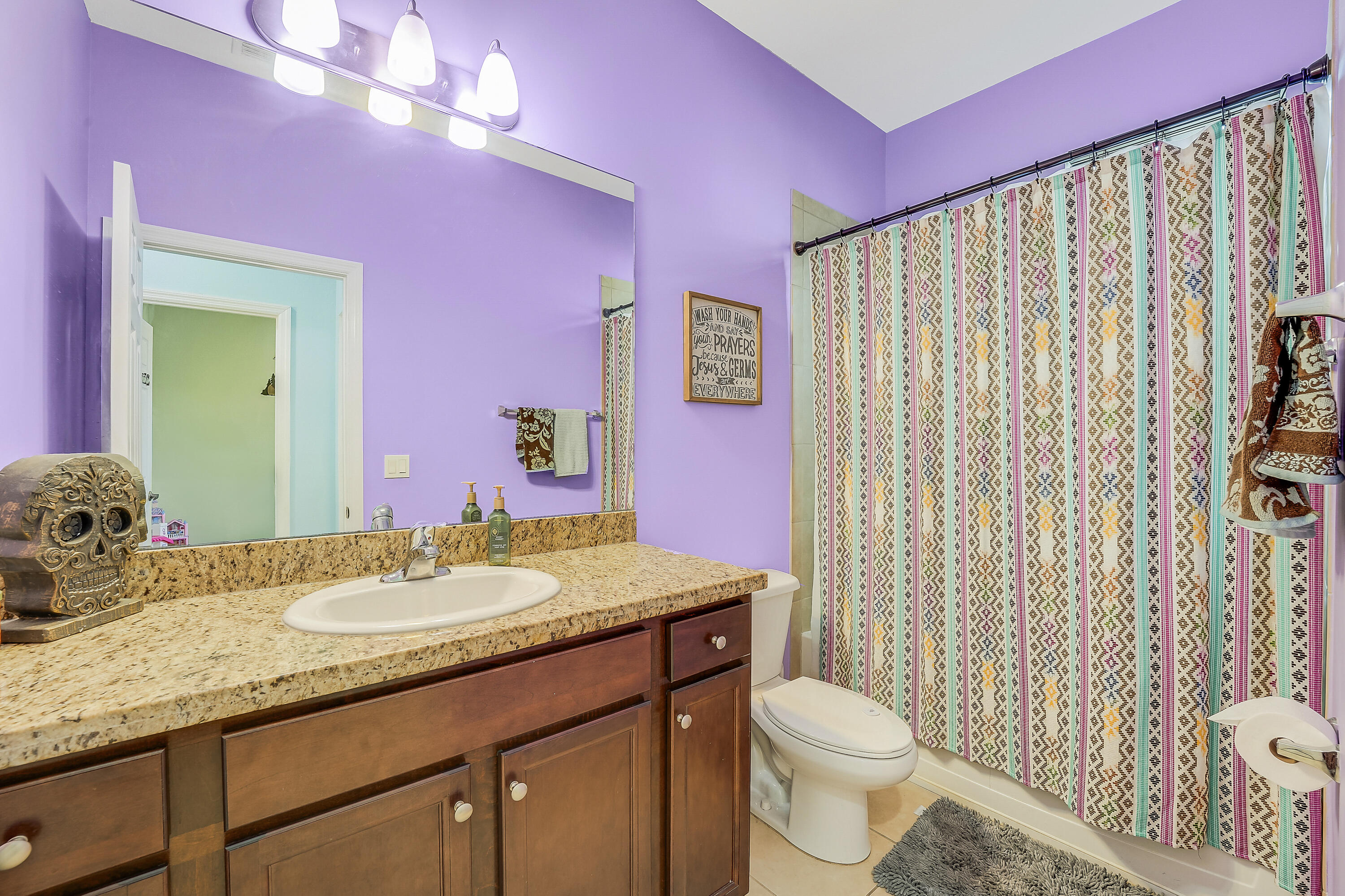 2900 Southwest 119th Way Miramar, FL 33025 - Photo 28 of 37 a bathroom with a granite countertop sink a toilet and shower curtain